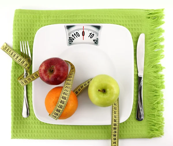Concepto de dieta. Frutas con cinta métrica en un plato como báscula de peso — Foto de Stock
