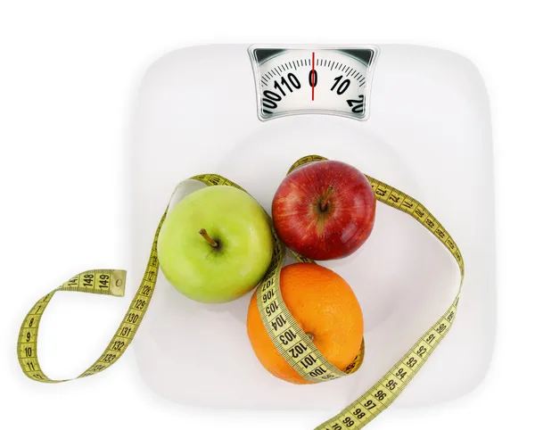 Concepto de dieta. Frutas con cinta métrica en un plato como el peso — Foto de Stock