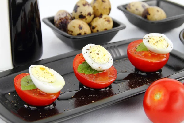 Quail eggs and tomatoes — Stock Photo, Image