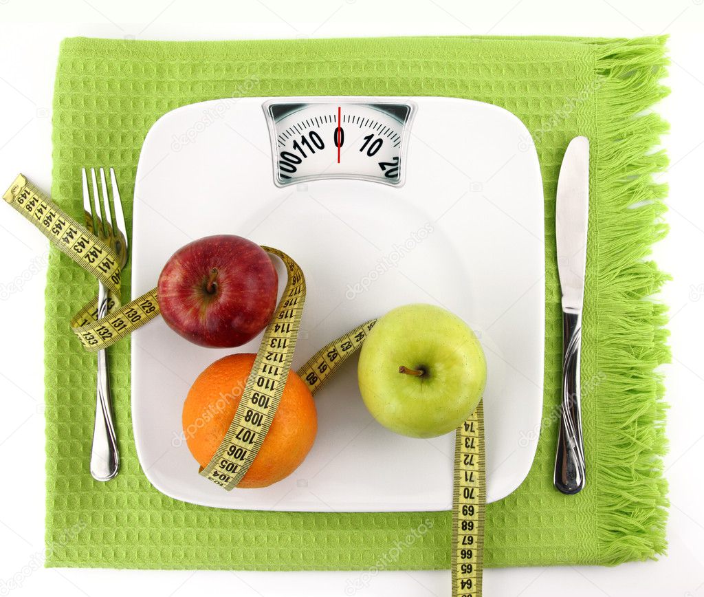 Diet concept. Fruits with measuring tape on a plate like weight scale