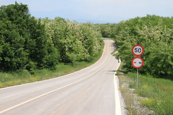 速度制限標識と曲がりくねった田舎道 — ストック写真