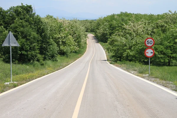 速度制限標識と曲がりくねった田舎道 — ストック写真