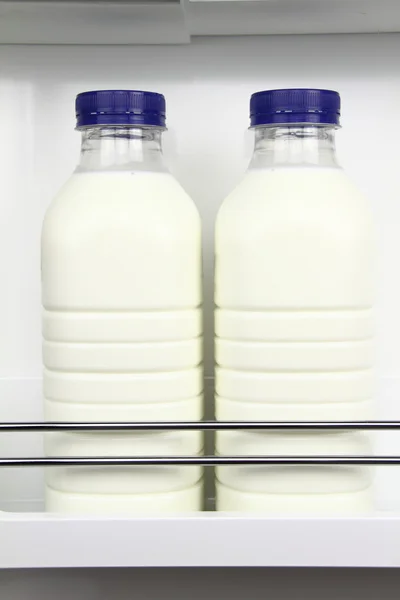 Botellas de leche fresca en la nevera — Foto de Stock