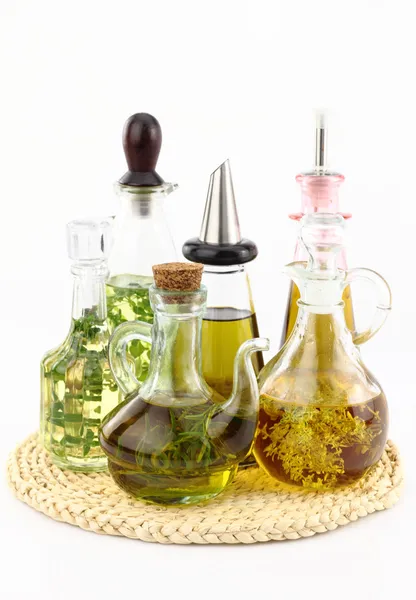 Различные бутылки оливкового масла с травами внутри — стоковое фото