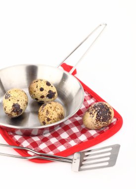 Frying pan with quail eggs on a white background clipart