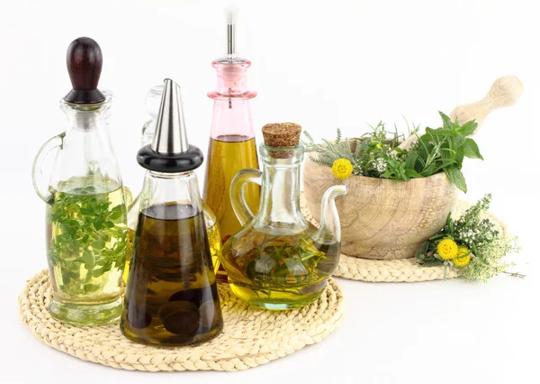 Mortero y mortero con hierbas y botellas de aceite de oliva —  Fotos de Stock