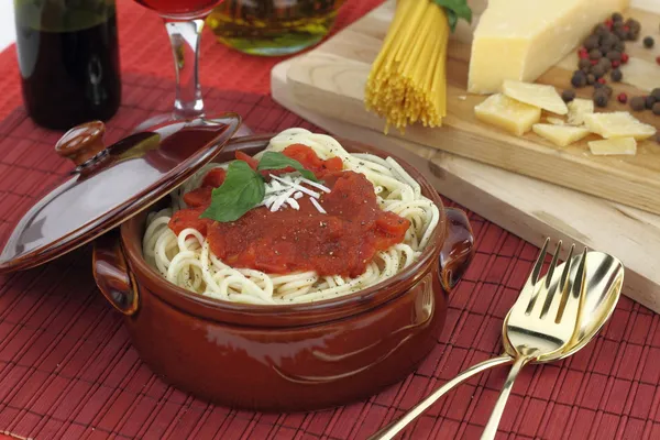 Massa de espaguete com molho de tomate, queijo e manjericão em uma panela de barro — Fotografia de Stock