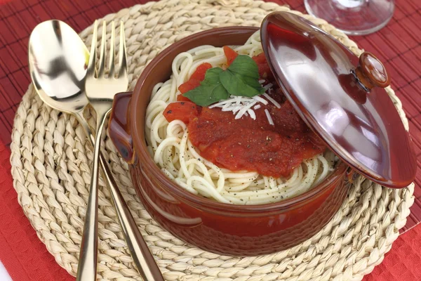 Massa de espaguete com molho de tomate, queijo e manjericão em uma panela de barro — Fotografia de Stock
