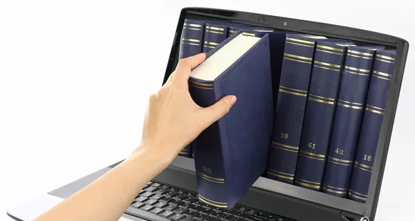 Ноутбук компьютер с книгами, изолированные на белом — стоковое фото