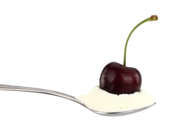 Spoon of cream with cherry on top clipart