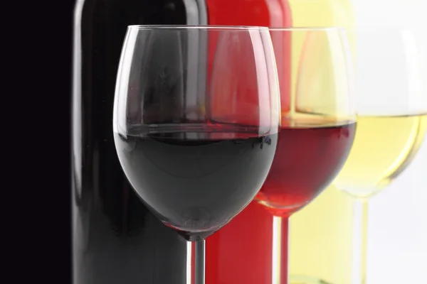 Три кольори вина в пляшках і келихах — стокове фото