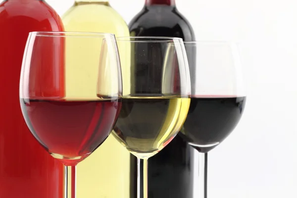 Три кольори вина в пляшках і келихах — стокове фото