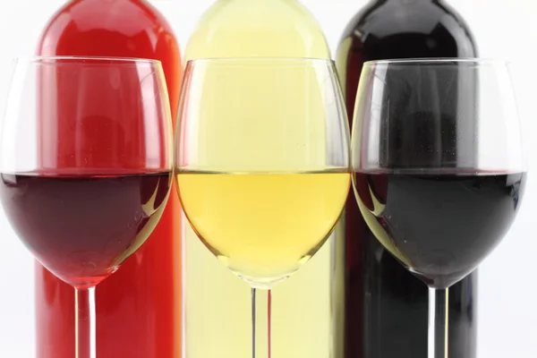Drie kleuren van wijn in flessen en glazen — Stockfoto