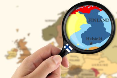 Magnifying glass over a map of Finland clipart