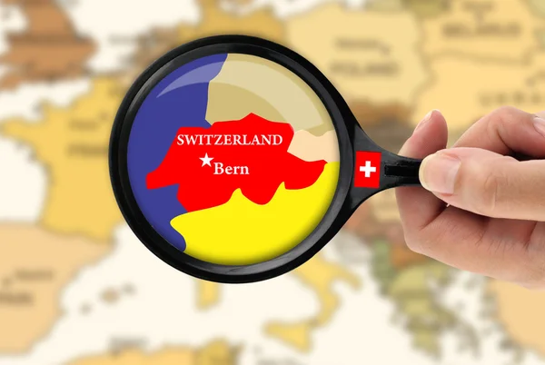 Ampliação de vidro sobre um mapa de Suíça — Fotografia de Stock