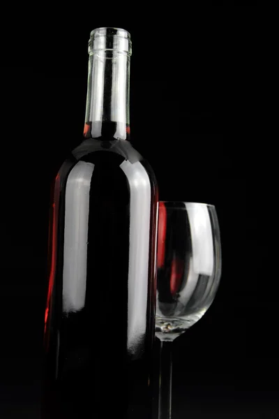 Botella de vino tinto y una copa de cristal — Foto de Stock