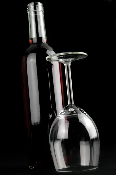 Üveg vörösbort és egy kristálytiszta borospohár — Stock Fotó