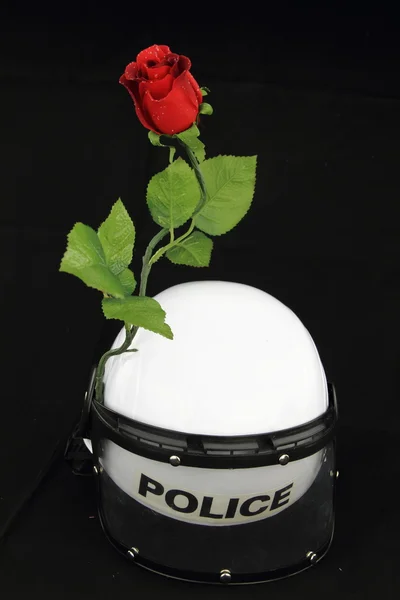 Полицейский шлем и роза. Концепция против насилия — стоковое фото