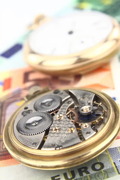 Часовой механизм с денежным фоном — стоковое фото