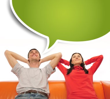 Young couple sitting on sofa and dreaming clipart