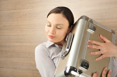 Portrait of a beautiful young businesswoman holding a suitcase l clipart