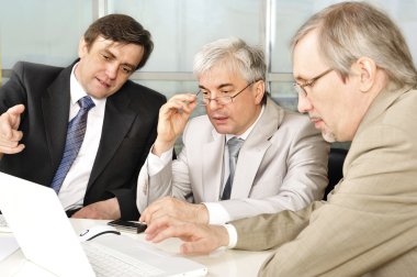 Portrait of three businessmen at the computer. clipart