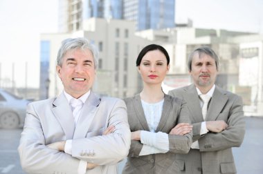 Portrait of three business outside.