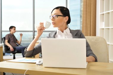 Portrait of a beautiful young businesswoman drinking water. clipart