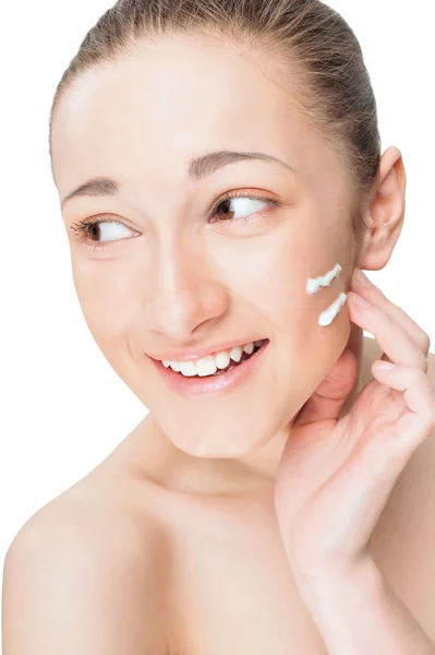 Retrato de una hermosa joven que se aplica crema en la cara un — Foto de Stock