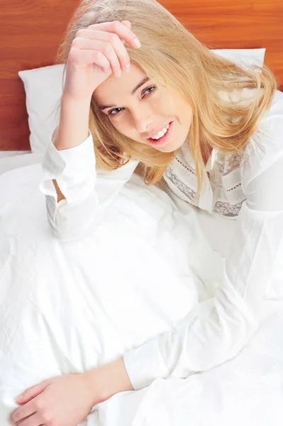 Portrét mladé ženy, kterým se v posteli — Stock fotografie