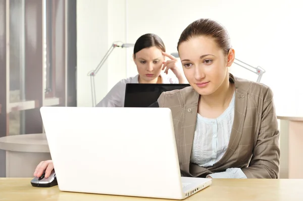 stock image Portrait of two women working at their desks