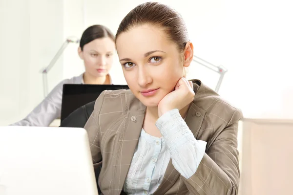 Portrait of two women working at their desks — Stock Photo, Image