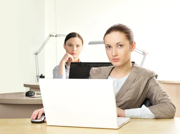 Portrait of two women working at their desks — Stock Photo, Image