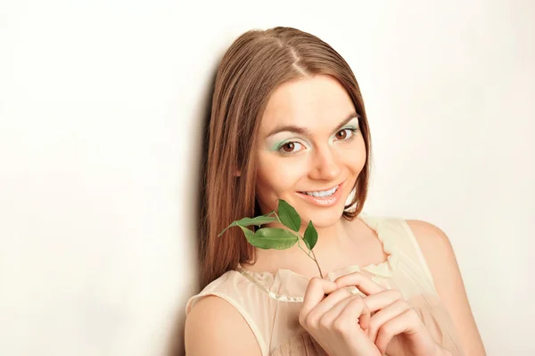 Yeşil bırakın tutan genç güzel kadın portresi — Stok fotoğraf