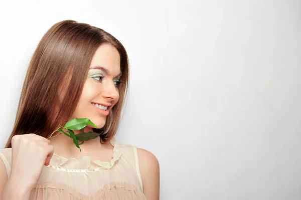 Portrait de jeune jolie femme tenant des feuilles vertes — Photo