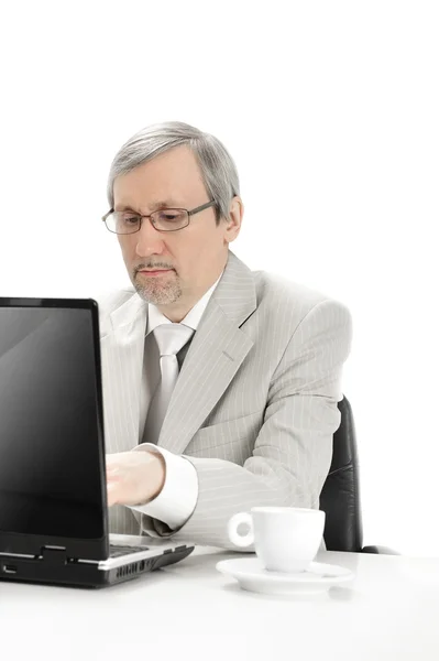 Portrait of an older businessman with a computer and a cup. — Stock Photo, Image