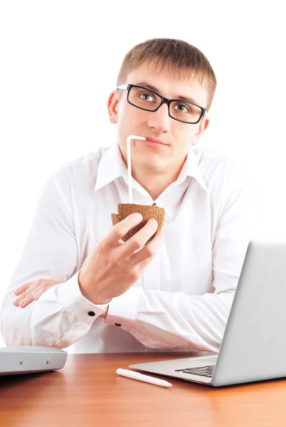 年轻男子坐在他的办公桌与便携式计算机和喝椰子的肖像 — 图库照片