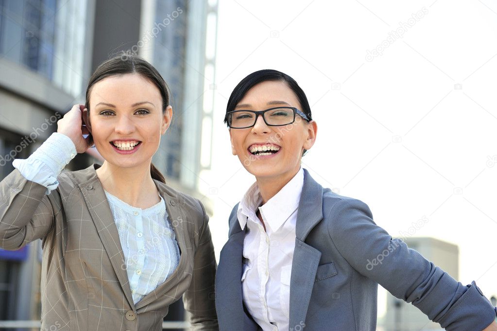 Portrait of two businesswomen outside.