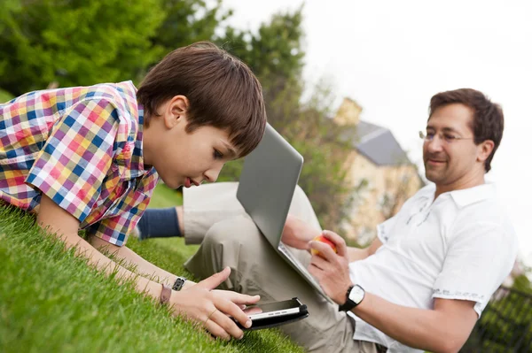 Mannen och unga boy hans son sitter utomhus — Stockfoto