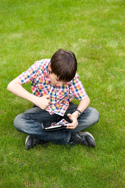 Νεαρό αγόρι σε εξωτερικούς χώρους στο γρασίδι στο κατώφλι — Φωτογραφία Αρχείου