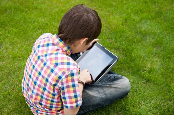 Jovem rapaz ao ar livre na grama no quintal — Fotografia de Stock