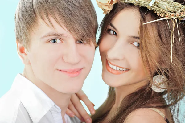 Smiling young man embracing his pretty girlfriend wearing hay ha — Stock Photo, Image