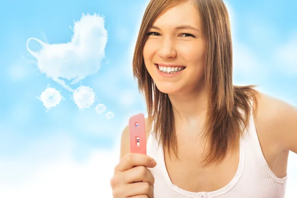 Portrait of young happy woman holding pregnancy test — Stock Photo, Image