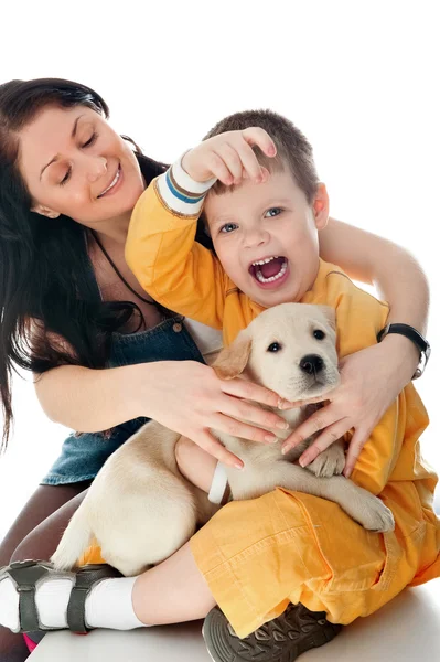Una familia feliz de dos con un perro sentado en flor, mirando a cam —  Fotos de Stock