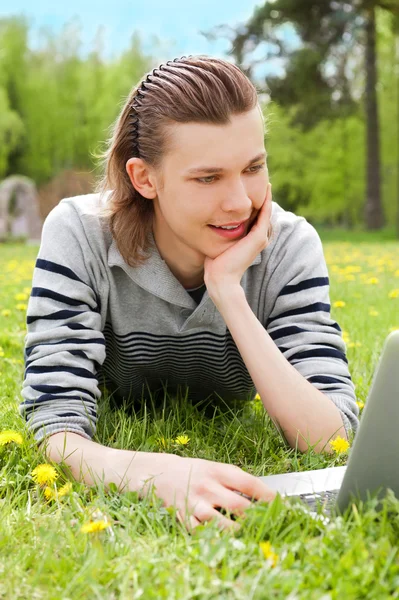 一个微笑男人与室外的笔记本电脑 — 图库照片