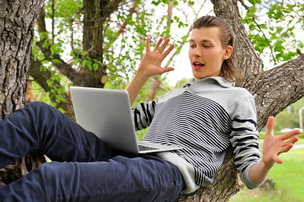 En leende man med laptop utomhus — Stockfoto