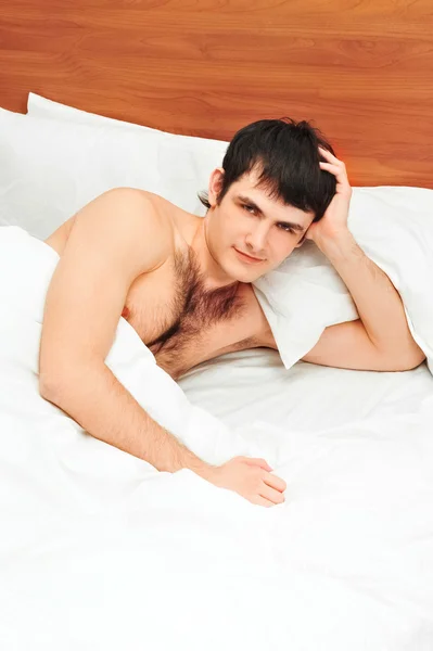 Hombre acostado en la cama sonriendo — Foto de Stock