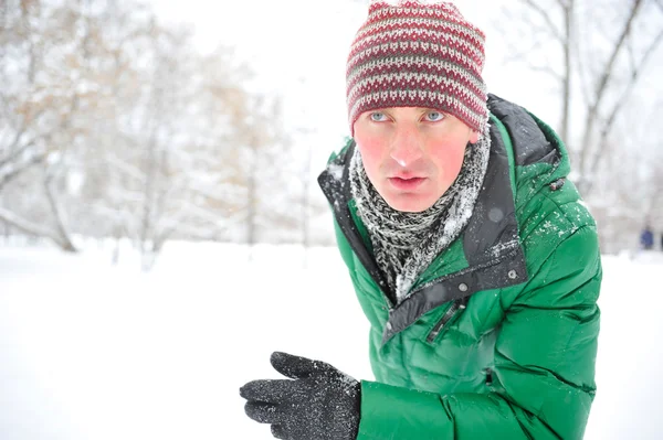 Closeup portrait of young man running in winter park — Stock Photo, Image