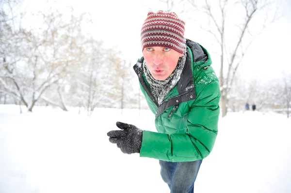 Портрет молодого человека, бегущего в зимнем парке — стоковое фото