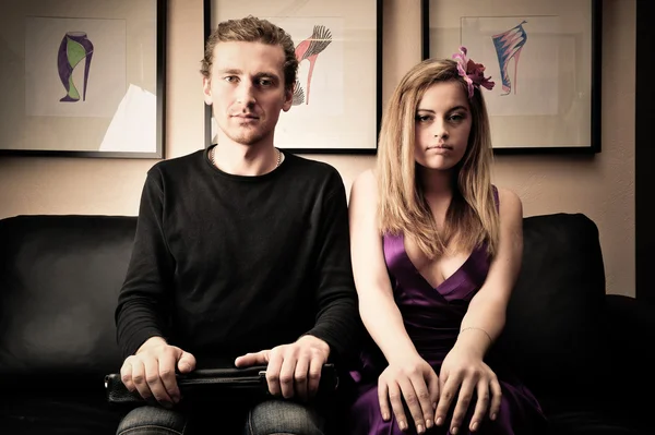Sorridente coppia attraente ricco alla moda seduto sul divano a ho — Foto Stock